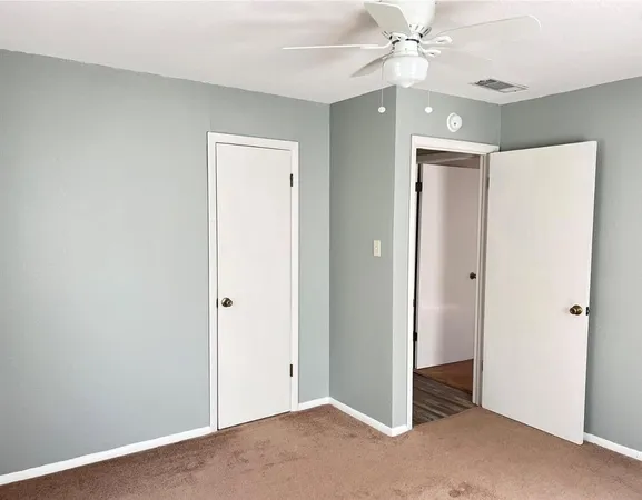 a view of an empty room with a ceiling fan