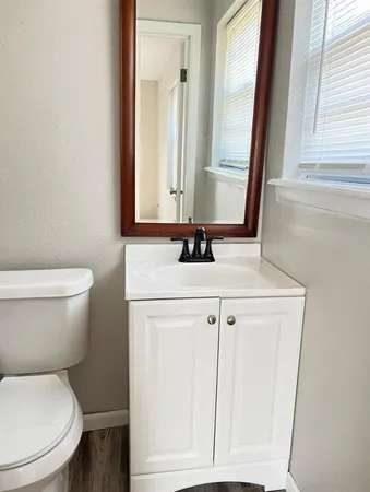 a bathroom with a sink a toilet a mirror and vanity