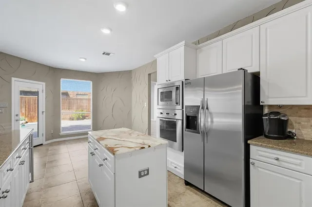 a kitchen with a refrigerator a stove and a sink