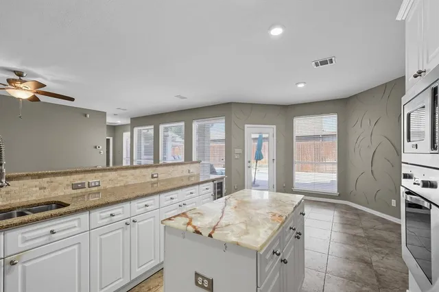 a spacious bathroom with a granite countertop sink and a large mirror