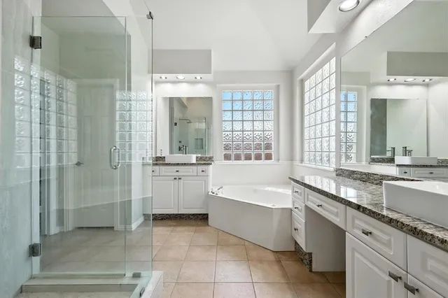 a large bathroom with a granite countertop tub sink shower and mirror