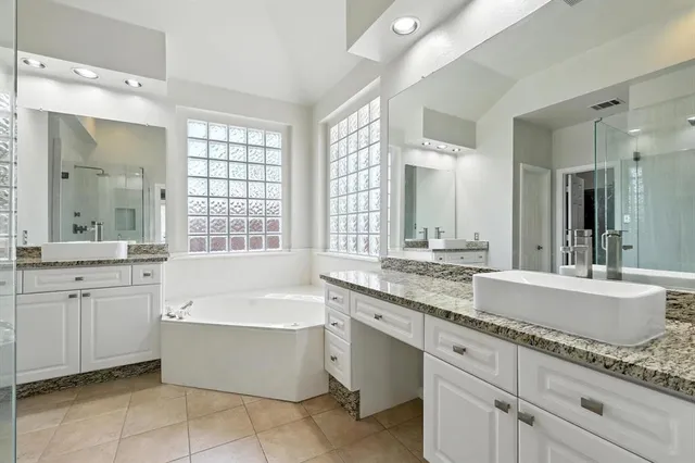a bathroom with a granite countertop bathtub sink and mirror