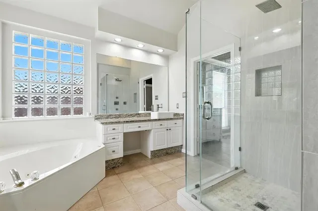 a spacious bathroom with a shower sink and mirror