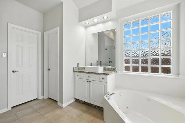 a bathroom with a bathtub sink and mirror