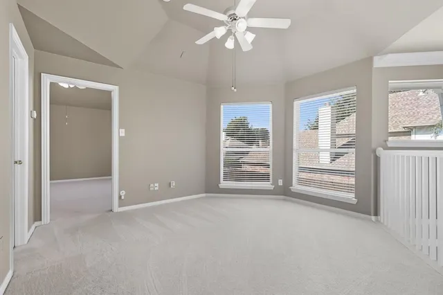 an empty room with windows and fan