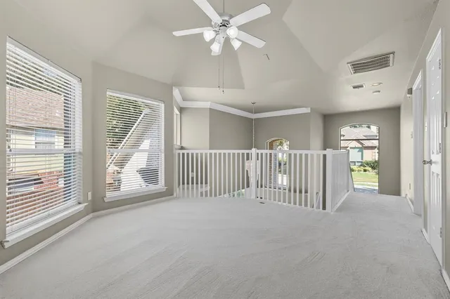 en view interior of a house with wooden floor windows and a ceiling fan