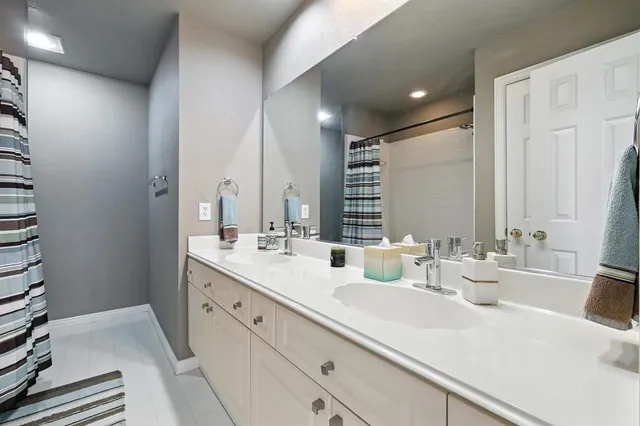 a bathroom with double vanity sinks and a mirror