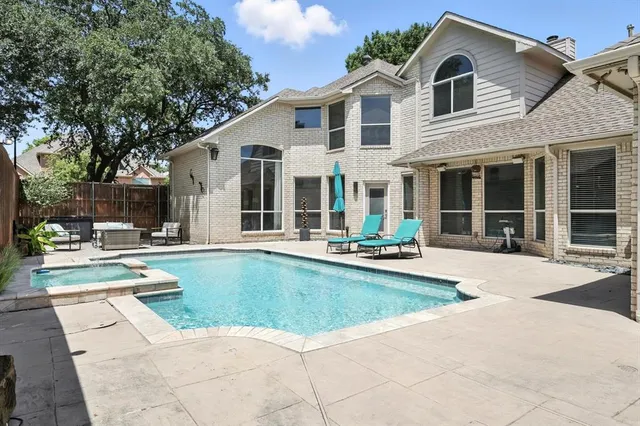 a view of a white house with swimming pool table and chairs
