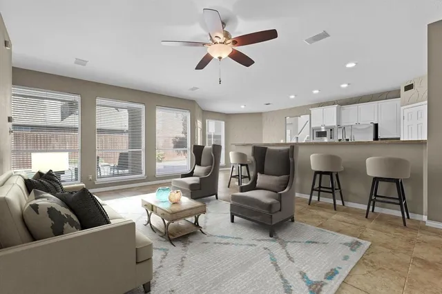 a living room with furniture and a large window with wooden floor