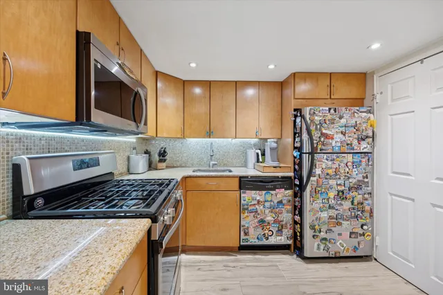 a kitchen with stainless steel appliances granite countertop a stove and a refrigerator
