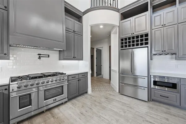 a kitchen with granite countertop stainless steel appliances and wooden floor