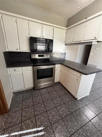 a kitchen with stainless steel appliances a sink a stove a microwave and cabinets