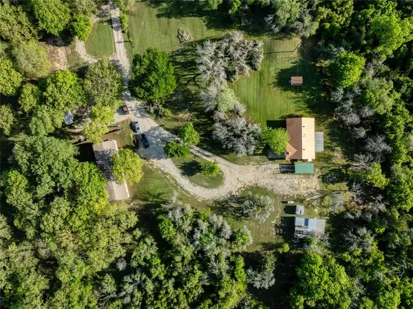 an aerial view of residential house with outdoor space and trees around
