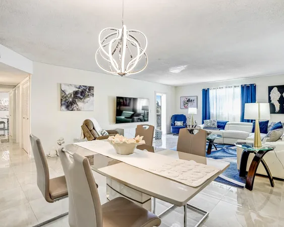 a living room with a table chairs and a dining table
