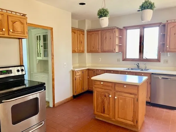 a kitchen with a sink stove top oven and cabinets