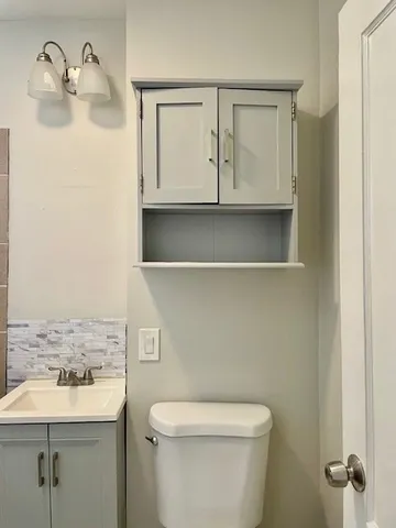 a bathroom with a toilet a sink a vanity and mirror