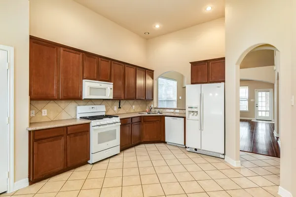 a kitchen with stainless steel appliances granite countertop a refrigerator and a stove top oven
