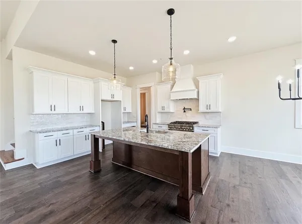 a large kitchen with stainless steel appliances granite countertop a lot of counter space and a sink