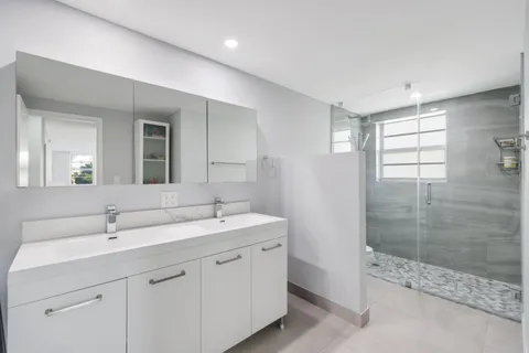 a spacious bathroom with a shower sink and mirror