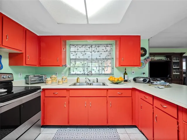 a kitchen with granite countertop a sink stove and cabinets