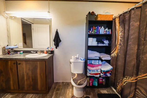 a bedroom with a bed a window and wooden floor