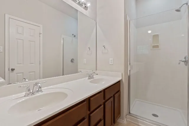 a bathroom with double vanity sinks and a mirror