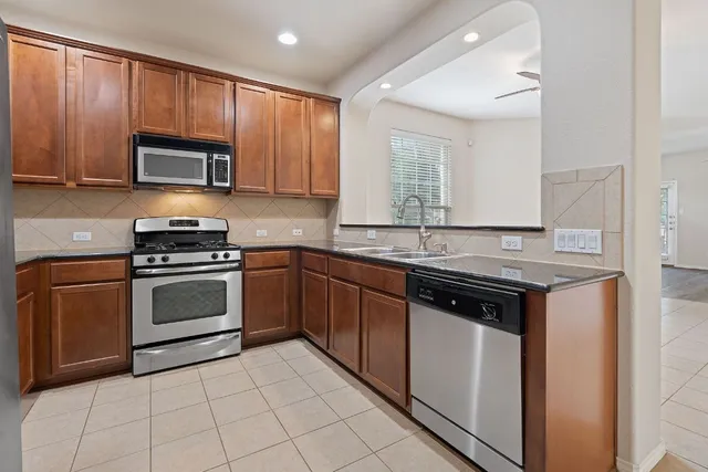 a kitchen with granite countertop a stove sink and cabinets