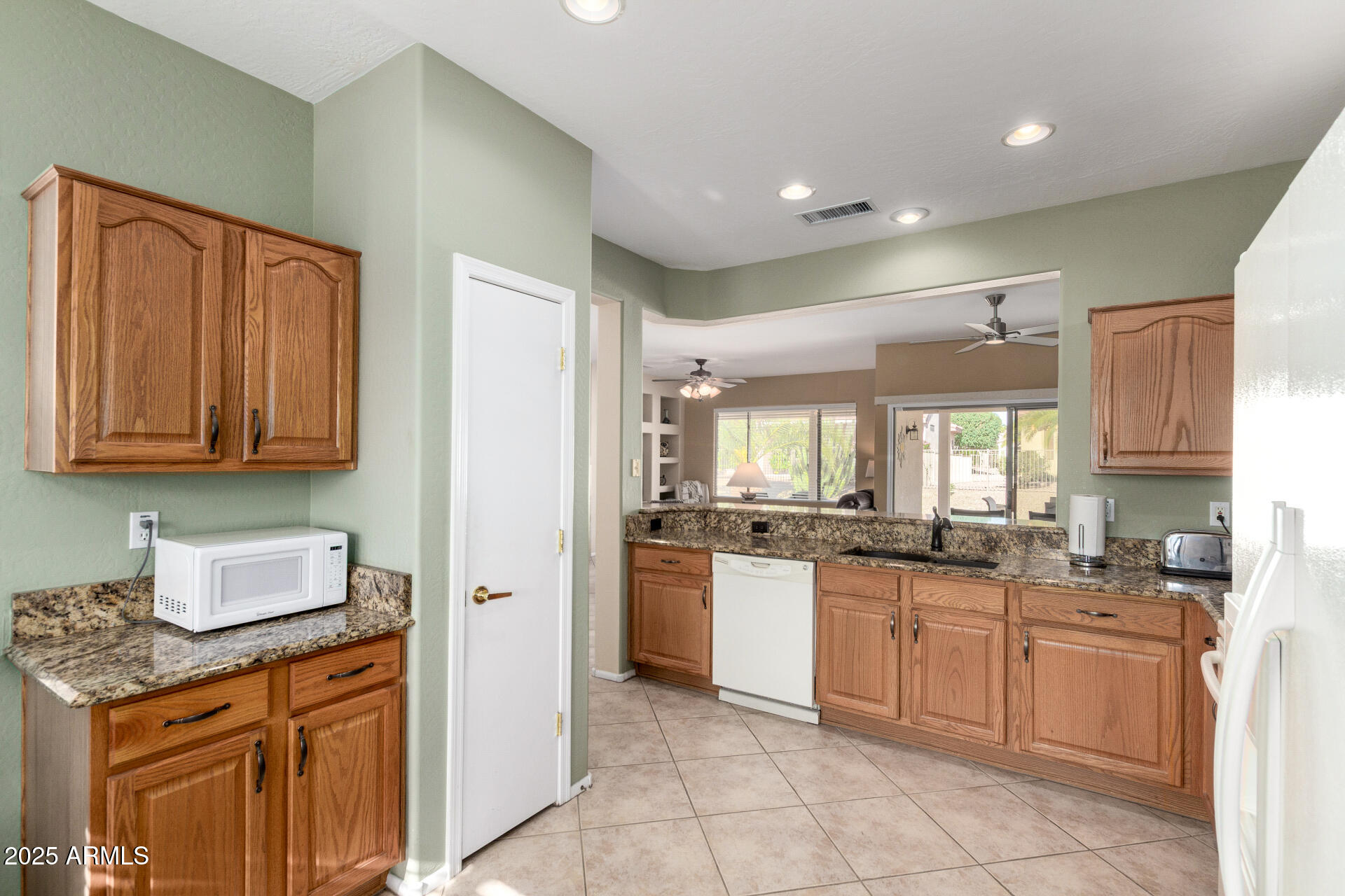 15448 West Moonlight Way Surprise, AZ 85374 - Photo 12 of 26 a kitchen with stainless steel appliances granite countertop a stove sink and cabinets