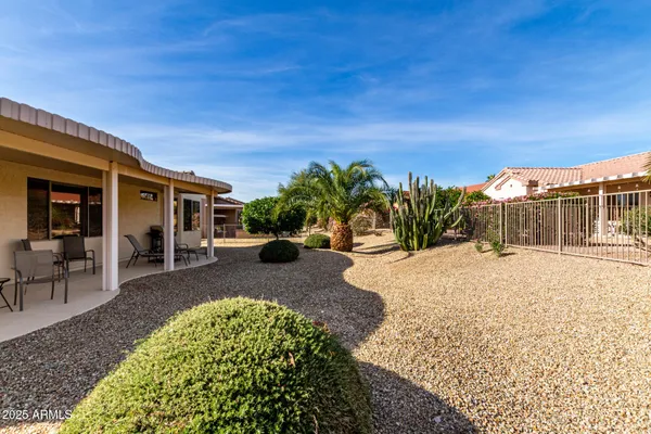 a view of a house with backyard and sitting area