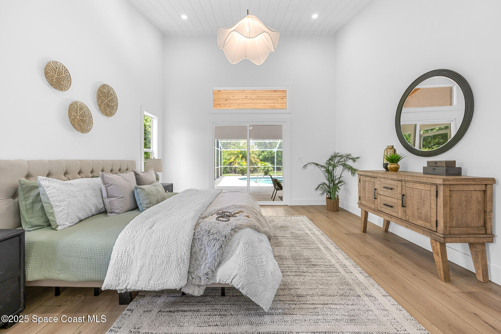 4340 Windover Way Melbourne, FL 32934 - Photo 24 of 42 a bedroom with a bed and a chandelier