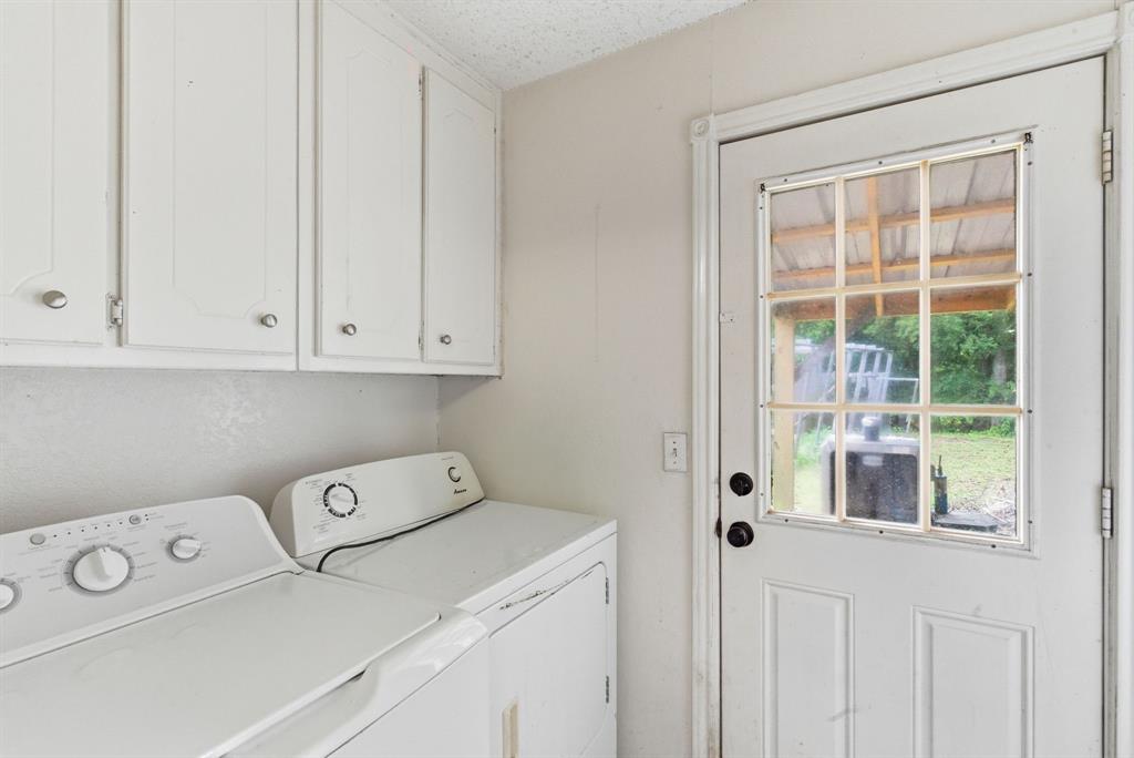 302 Tower Road Rio Vista, TX 76093 - Photo 19 of 29 Utility room featuring white cabinetry, a glass-paned exterior door, and light-toned walls
