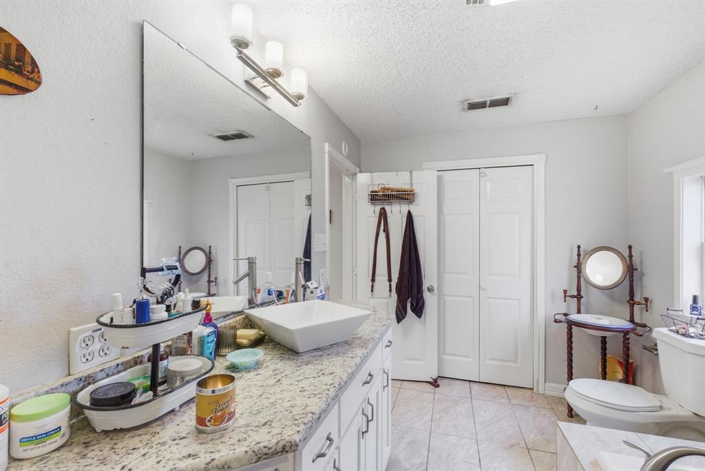 302 Tower Road Rio Vista, TX 76093 - Photo 21 of 29 Bathroom vanity featuring a vessel sink, single-handle faucet, and granite-style countertop