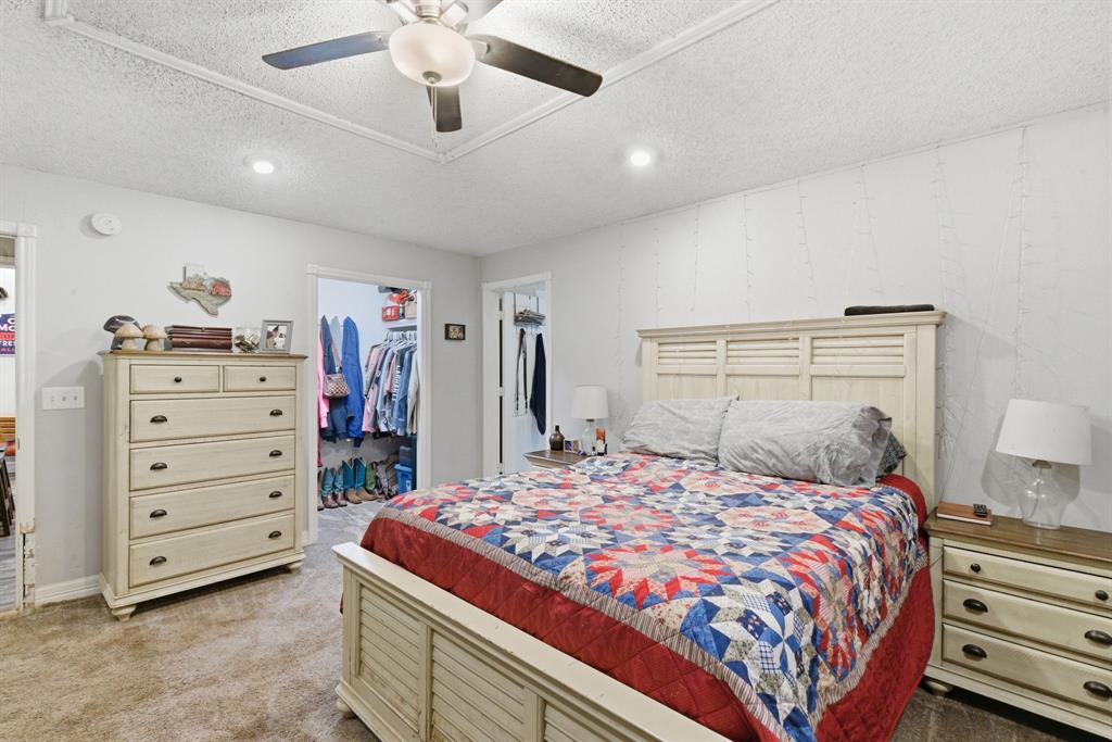 302 Tower Road Rio Vista, TX 76093 - Photo 23 of 29 Carpeted bedroom featuring a ceiling fan, recessed lighting, and a walk-in closet with built-in shelving