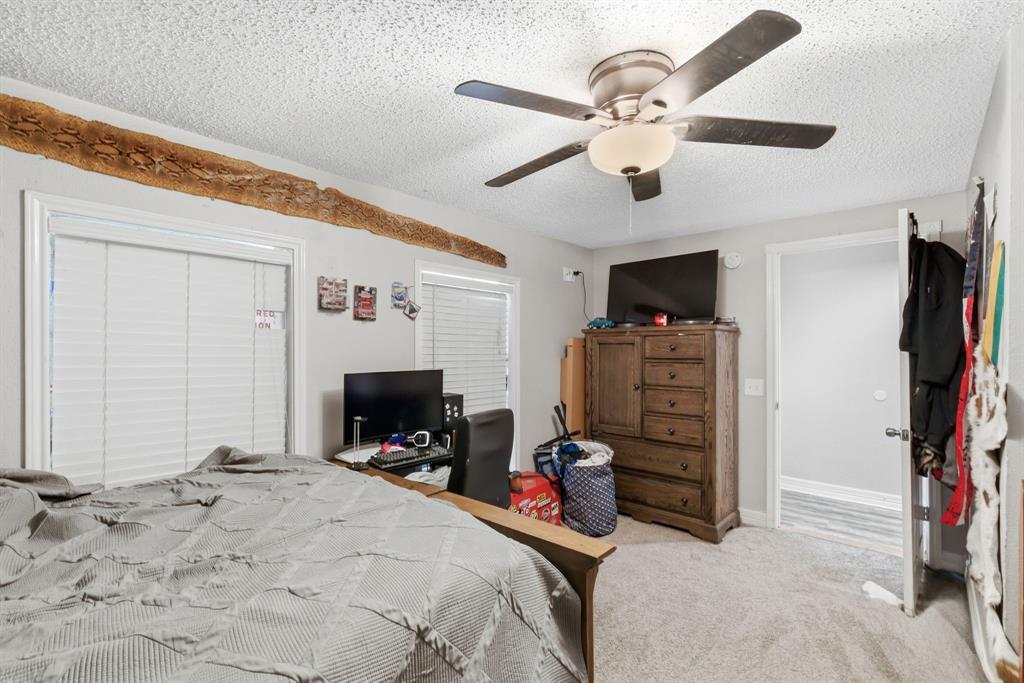 302 Tower Road Rio Vista, TX 76093 - Photo 26 of 29 Bright room featuring two windows with horizontal blinds, a ceiling fan with integrated lighting, and light-colored carpet flooring