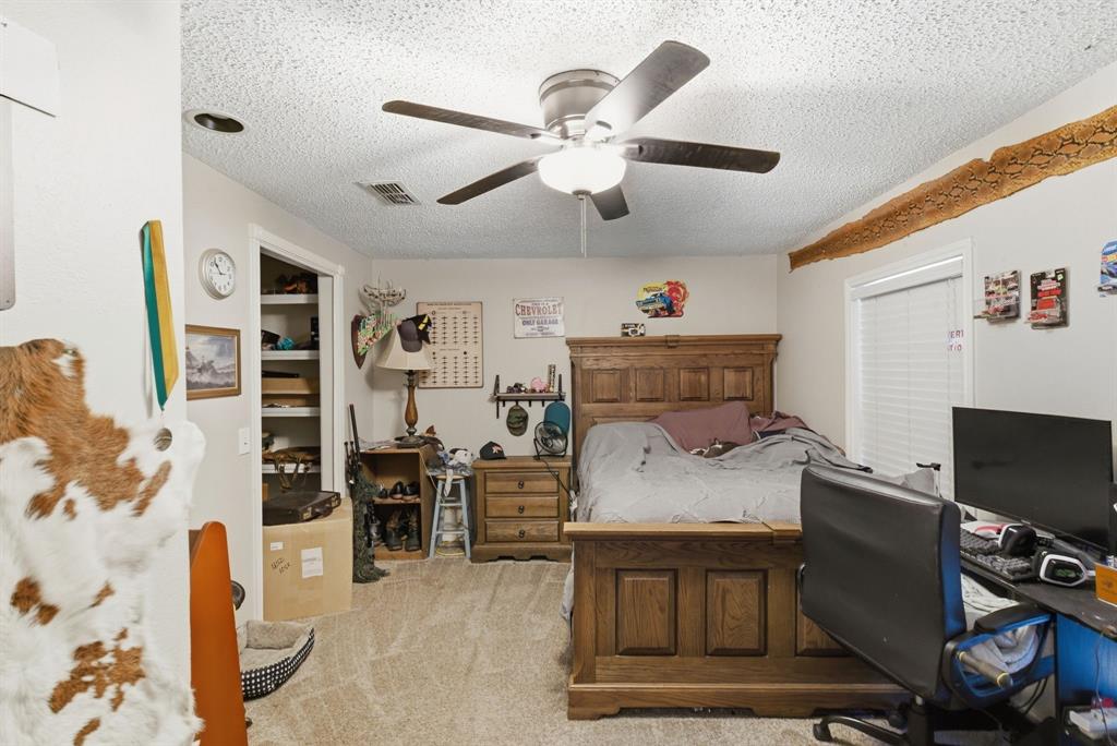 302 Tower Road Rio Vista, TX 76093 - Photo 27 of 29 Carpeted room featuring a ceiling fan with integrated lighting, a window with blinds, and a built-in closet with shelving