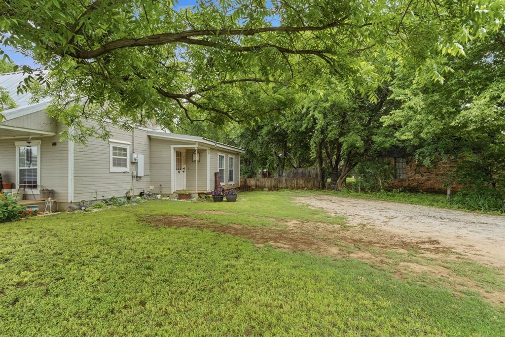 302 Tower Road Rio Vista, TX 76093 - Photo 5 of 29 Exterior featuring light-colored siding, a metal roof, and a covered front porch with a double entry door