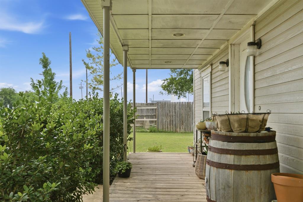 302 Tower Road Rio Vista, TX 76093 - Photo 6 of 29 Covered wood-finish porch featuring vertical support columns, horizontal siding, and exterior lighting fixtures