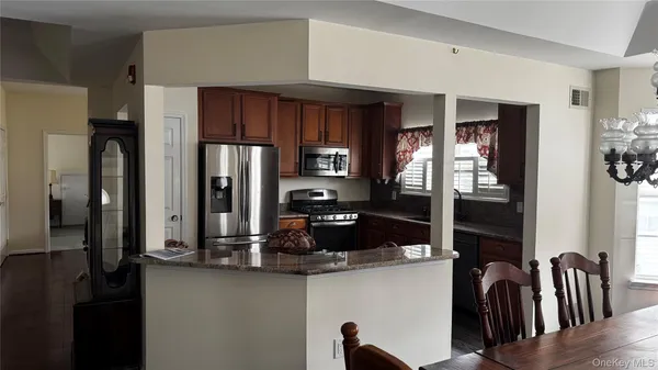 a kitchen with stainless steel appliances granite countertop a refrigerator and a sink
