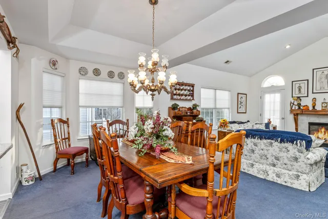 a view of a dining room with furniture and chandelier