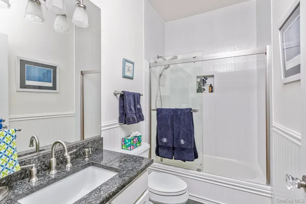 a bathroom with a granite countertop sink toilet and shower