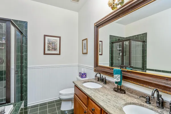 a bathroom with a granite countertop sink a toilet and a mirror