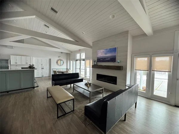 a view of a room with lots of wooden furniture and windows