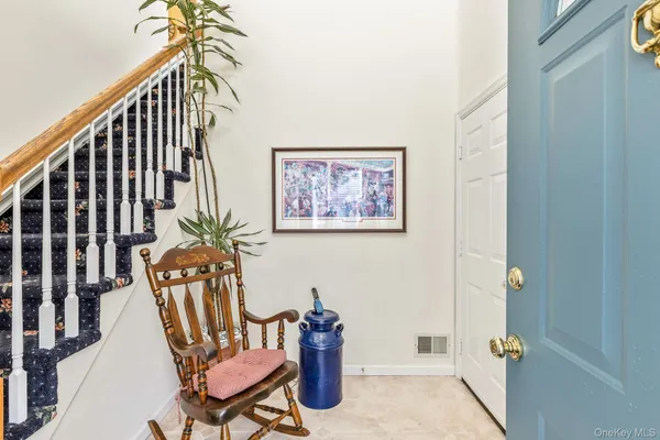 a view of a hallway with furniture and wooden floor
