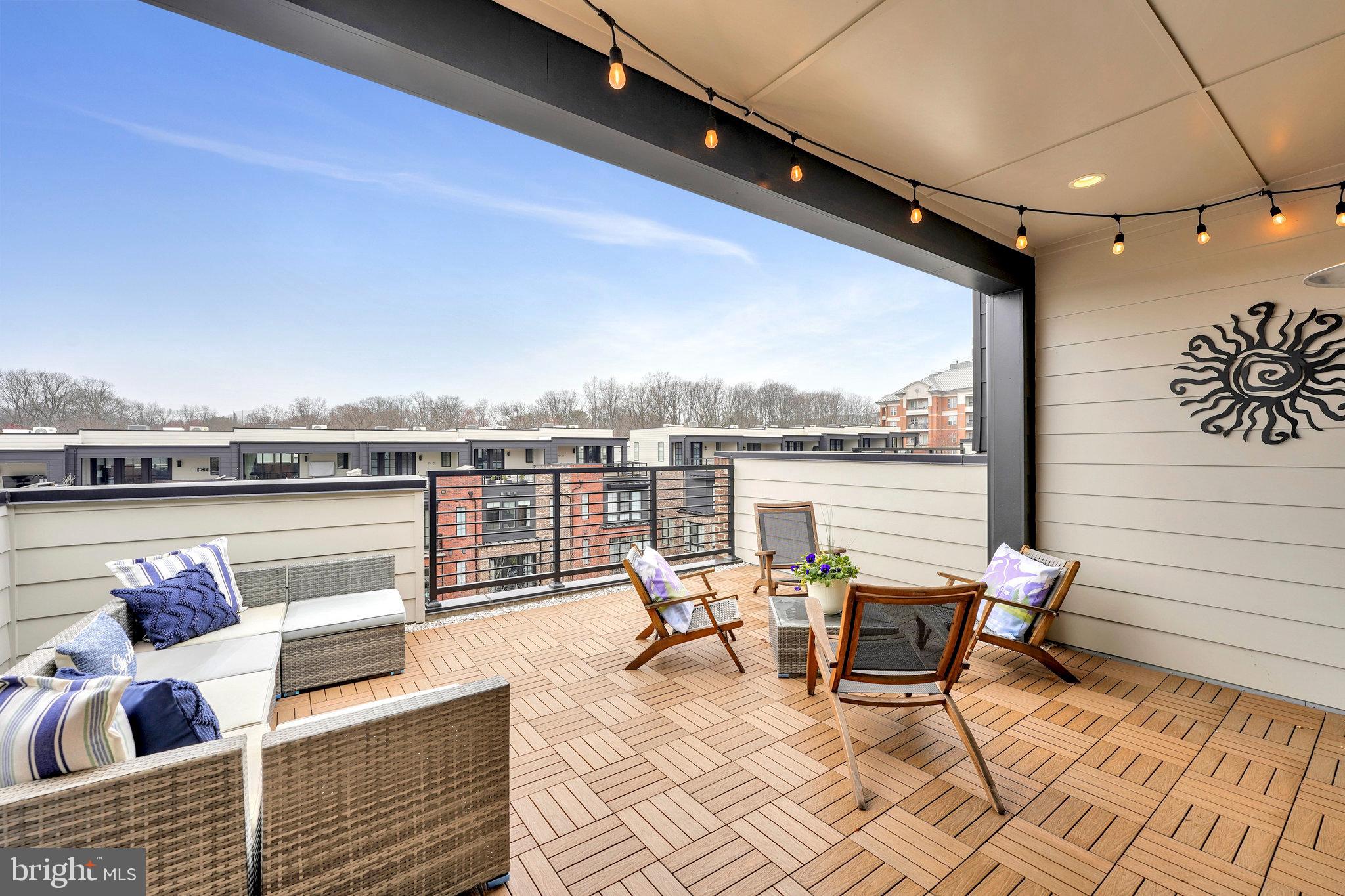 11716 Paysons Way Reston, VA 20191 - Photo 30 of 34 a roof deck with a table and chairs next to a yard
