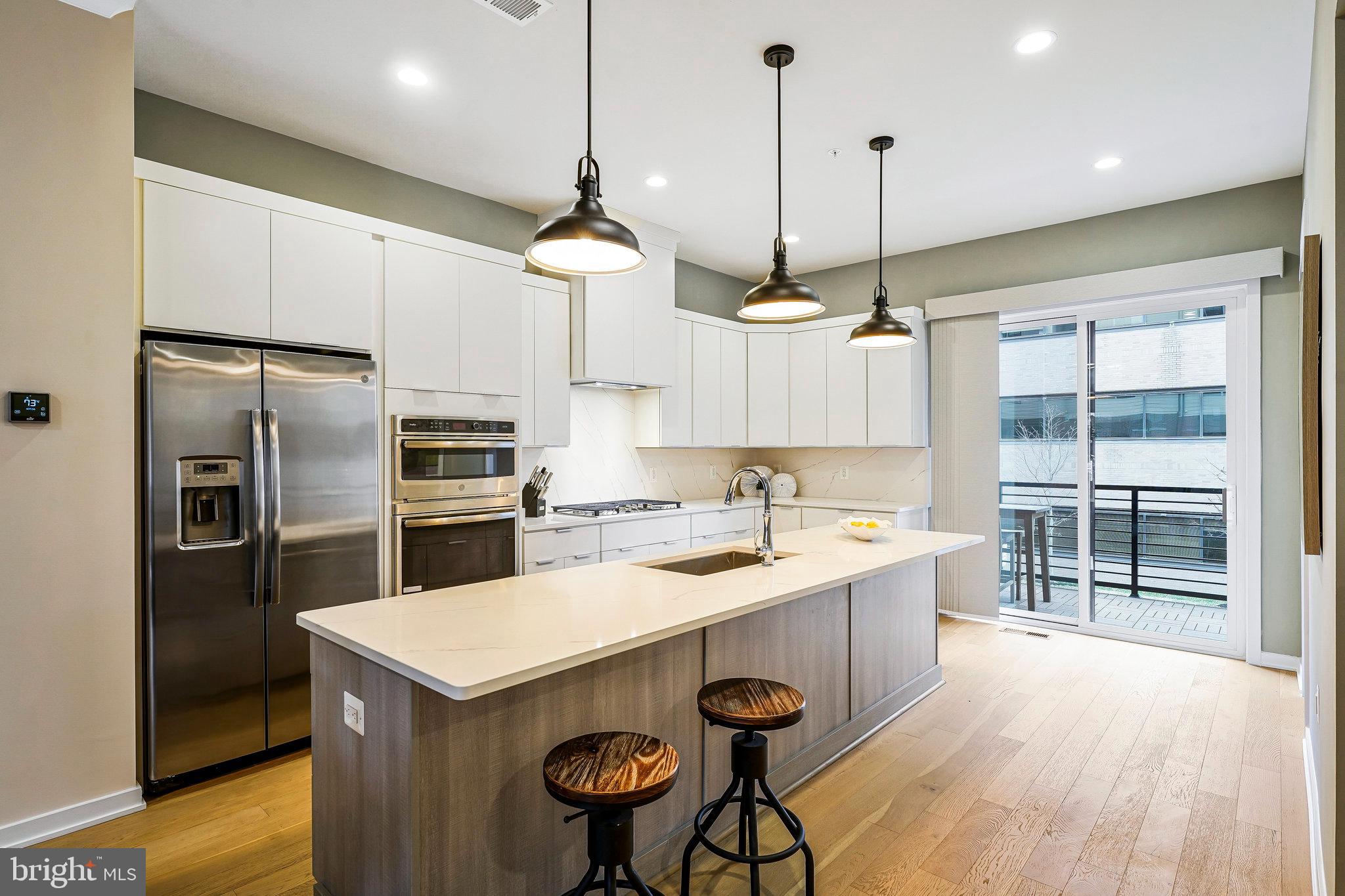 11716 Paysons Way Reston, VA 20191 - Photo 7 of 34 a kitchen with a refrigerator a sink and wooden floor