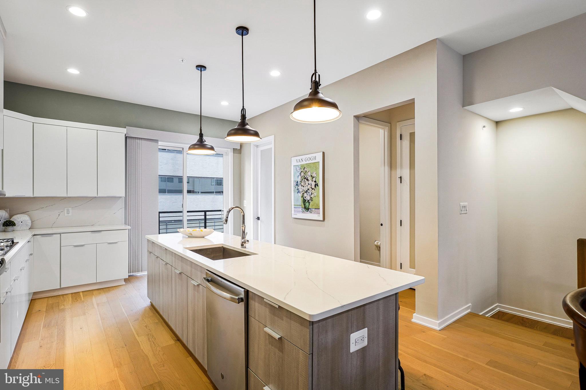 11716 Paysons Way Reston, VA 20191 - Photo 8 of 34 a kitchen with a stove a sink a center island and cabinets