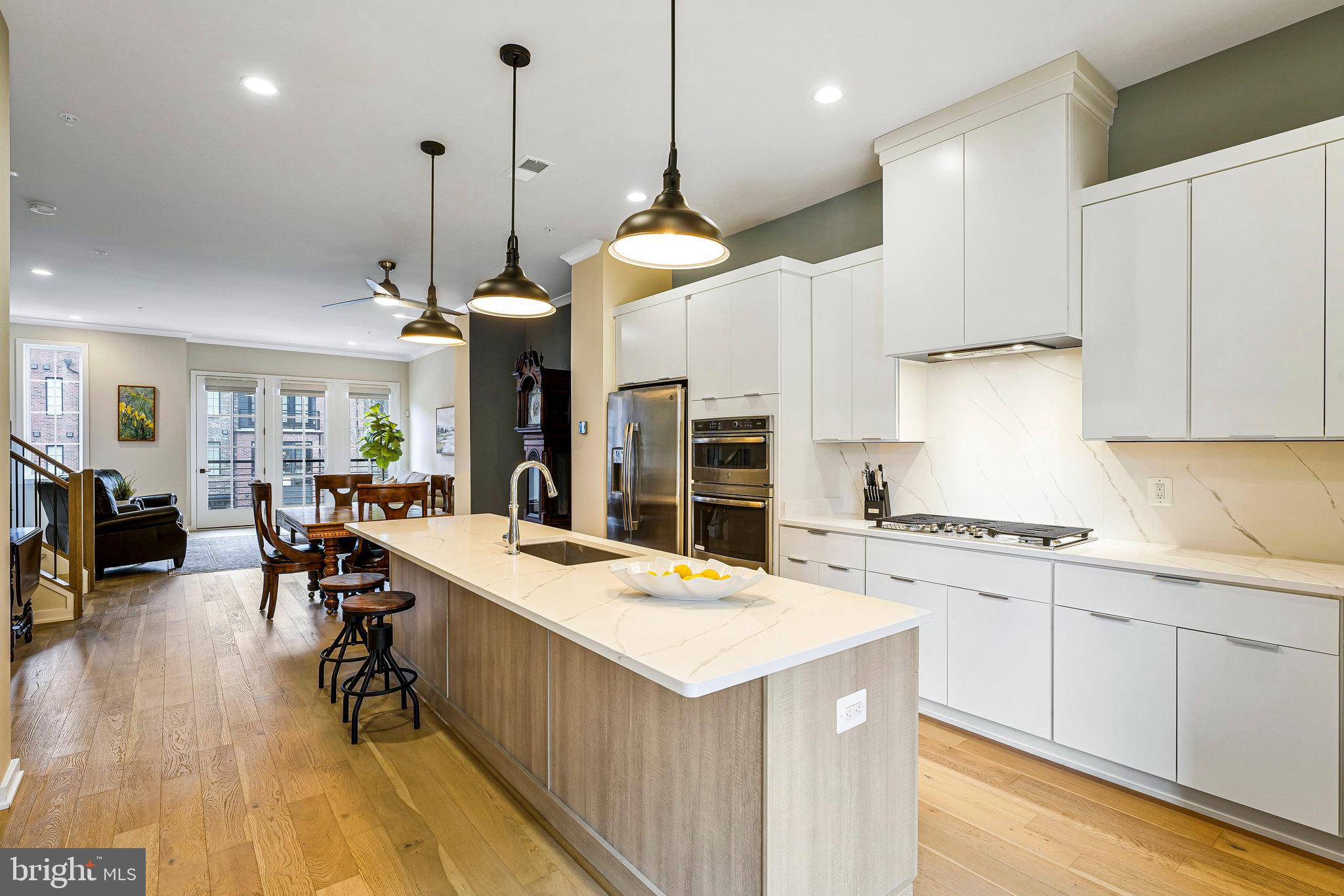 11716 Paysons Way Reston, VA 20191 - Photo 10 of 34 a kitchen with a stove a refrigerator a sink dishwasher with a dining table and chairs with wooden floor