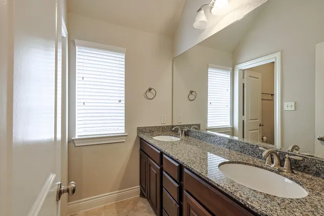 an empty room with chandelier fan and windows