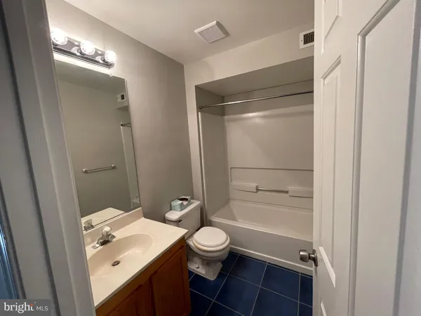 a bathroom with a granite countertop sink toilet a mirror and shower