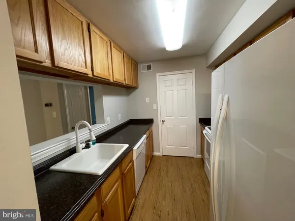 a kitchen with granite countertop a sink stove and refrigerator